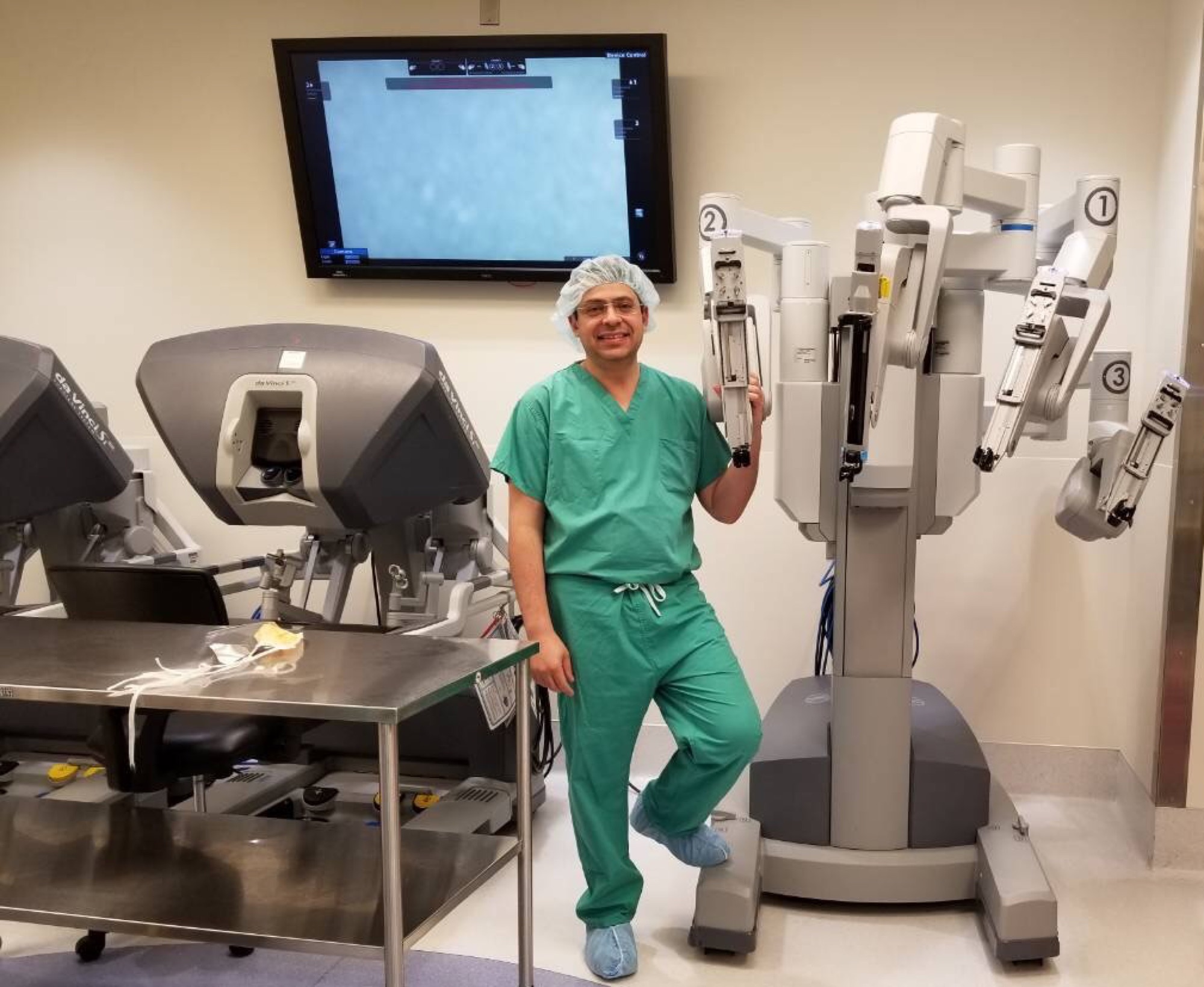 Dr. Kader standing beside the da Vinci robotic surgical system
